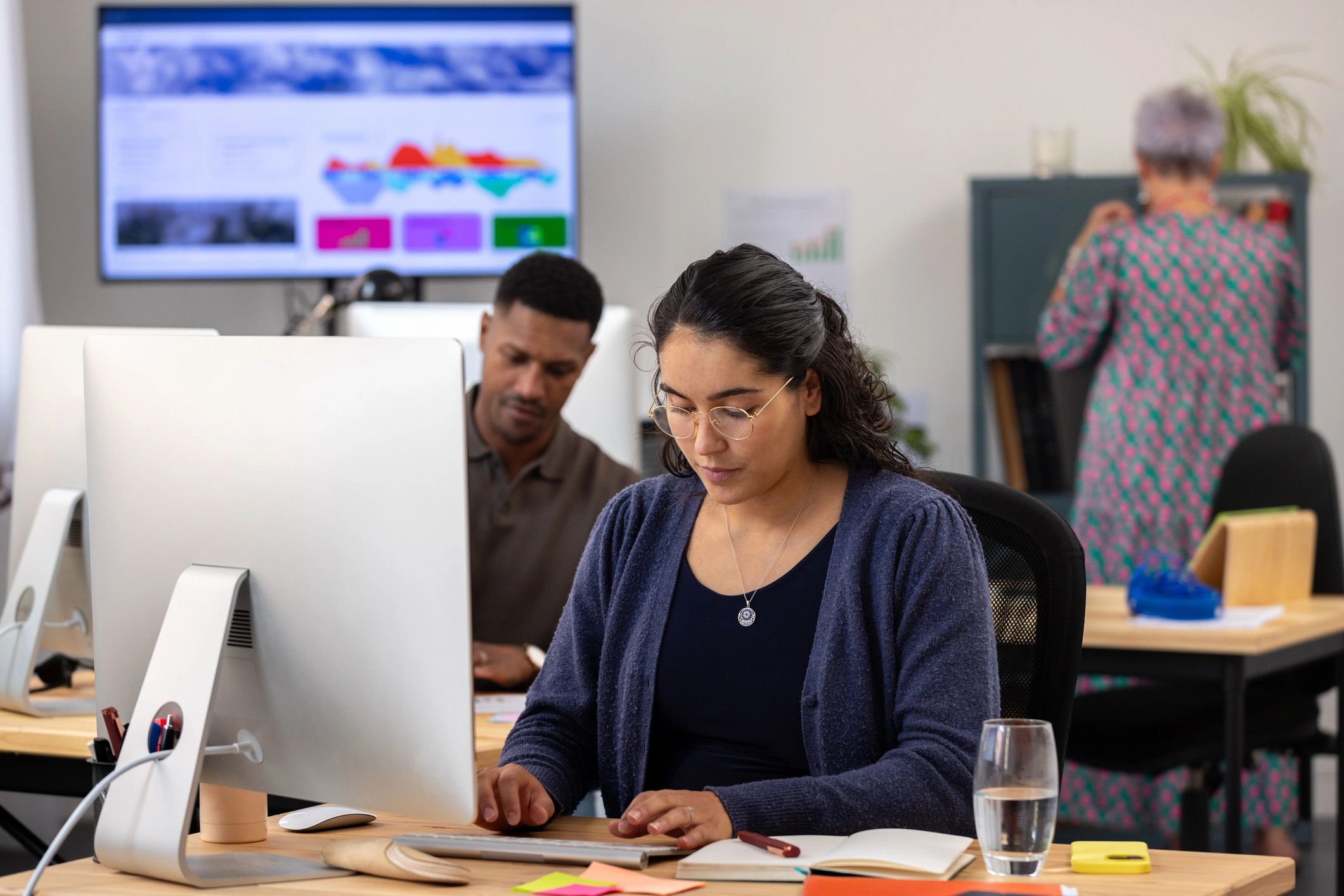 Team working in an office with data on a screen